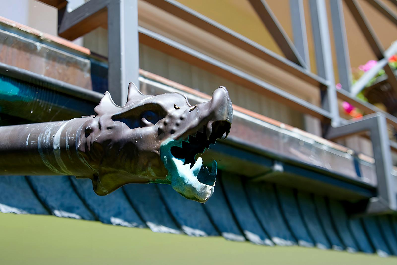 Gutter Guard Installation in Piscataway NJ — Intricate dragon-headed drainpipe detail on an exterior home, showcasing artistic bronze design.